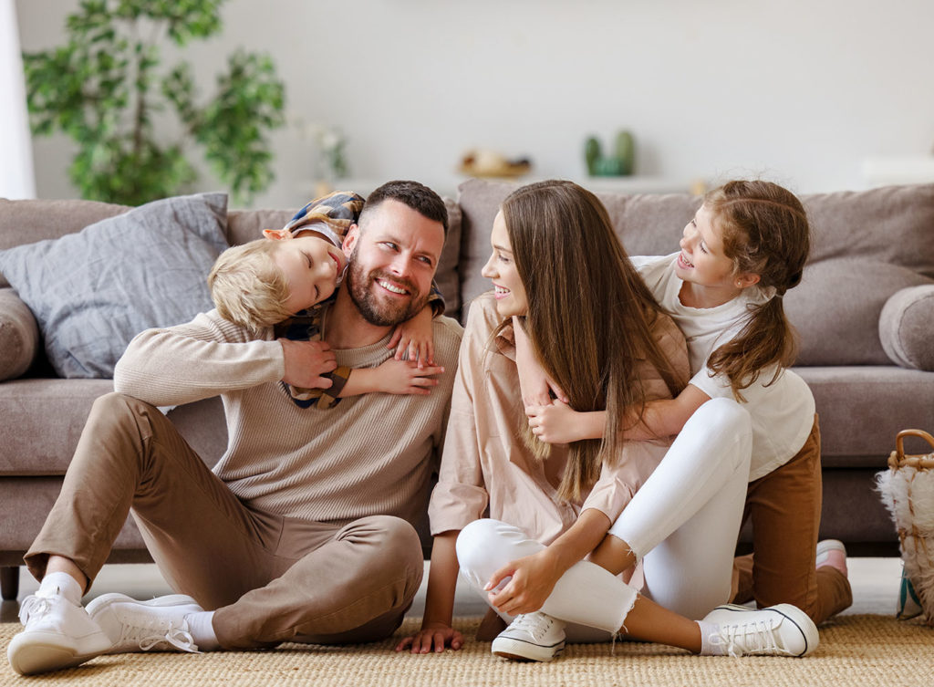 happy family sitting on the floor of their home reassured by their home insurance collinsville illinois